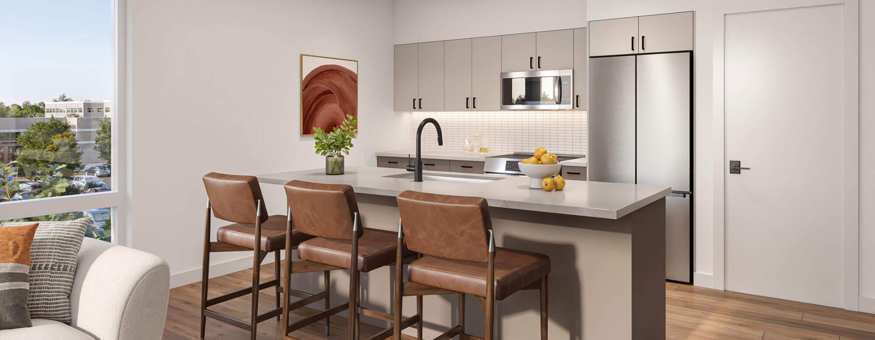 Modern kitchen with white cabinets, stainless steel appliances, and a large island with brown leather stools in a light-filled apartment.