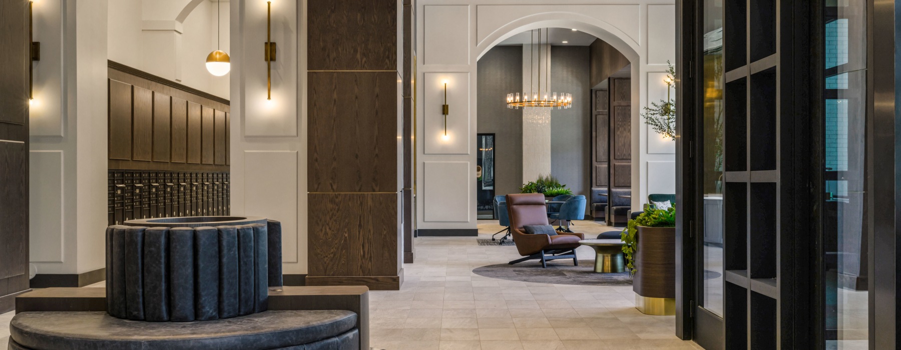 Modern apartment lobby at Broadstone Saratoga featuring stylish seating, statement lighting fixtures, and a sophisticated design with wood and brass accents.