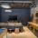 Modern entertainment lounge at Broadstone Saratoga featuring a pool table, shuffleboard, large TV, and comfortable seating with an industrial-chic design.