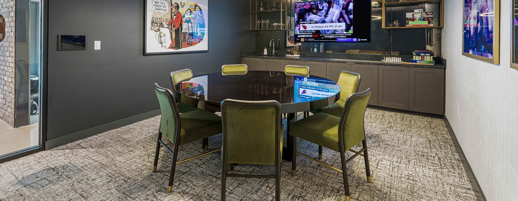 Cozy game room at Broadstone Saratoga with a round table, TV, and vintage decor.