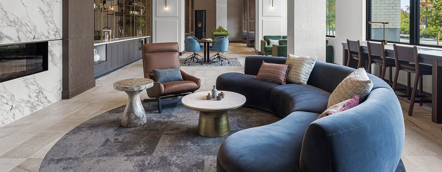 Modern apartment lobby at Broadstone Saratoga featuring stylish seating, statement lighting fixtures, and a sophisticated design with wood and brass accents.