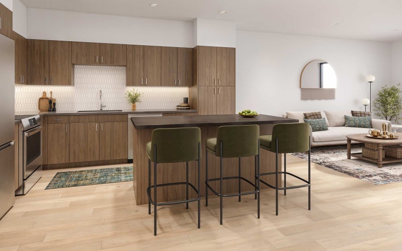 Stylish kitchen with wood cabinetry, a spacious island, and green velvet bar stools in an open-concept living area